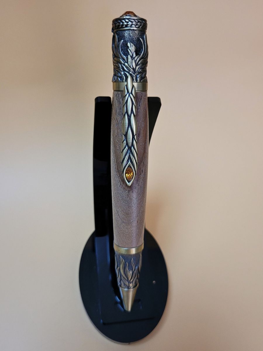 stylo bille de légende pégase en bronze et noyer surmonté de strass un oiseau sur capuchon dont le queue forme l'épingle ciselée et raffinée