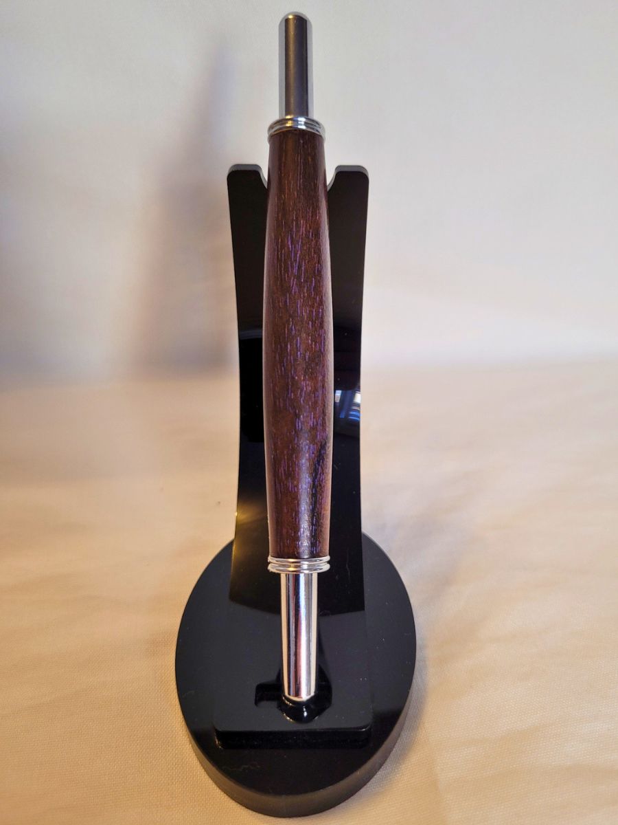 Découd‑vite en bois de fer wacapou, finition chromée brillante, outil couture haut de gamme présenté sur support noir.