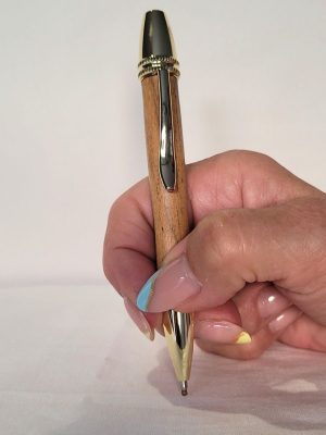 Stylo Alliance en bois de grenadille et finitions dorées tenu en main, système twist avec cartouche Parker – design élégant et ergonomique.