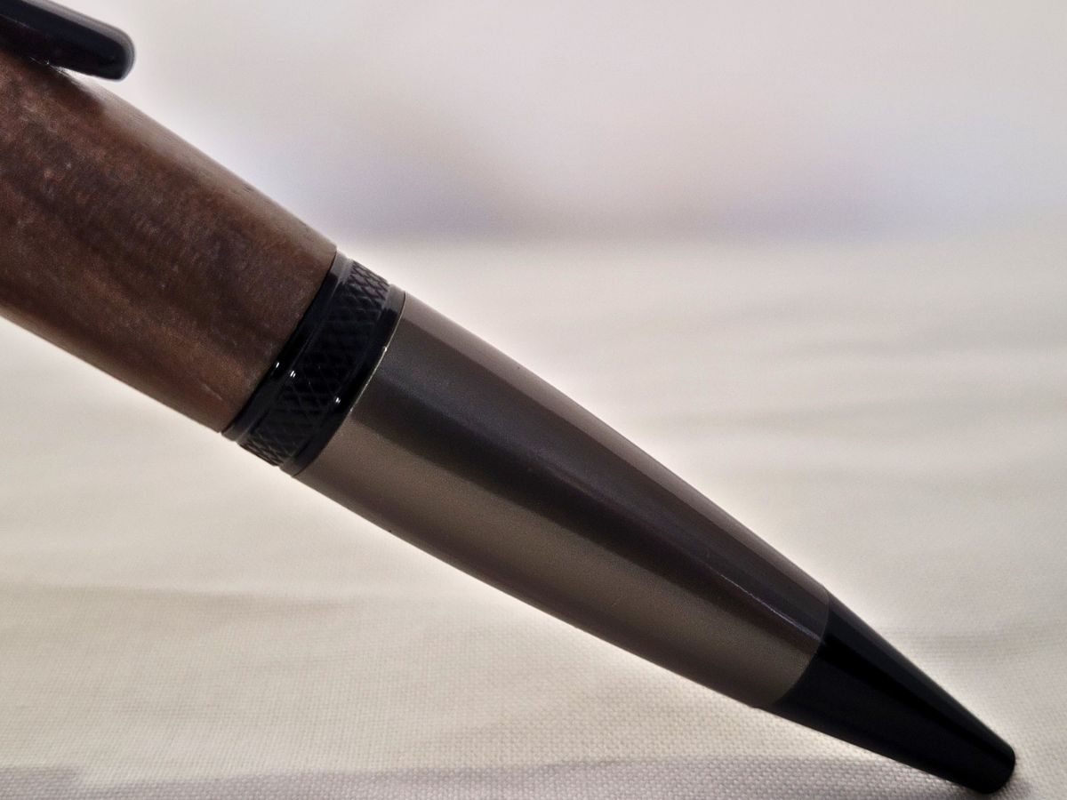 Détail de la pointe titane gris et de la bague noire ciselée du stylo bille Élégance Cerisier