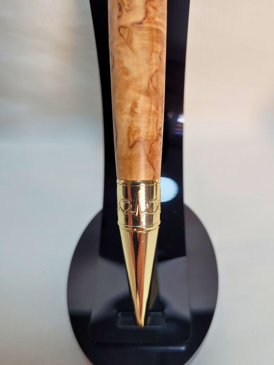 "Pointe du stylo médical en loupe de bouleau, placage or brillant et gravure de battements de cœur, finition artisanale."