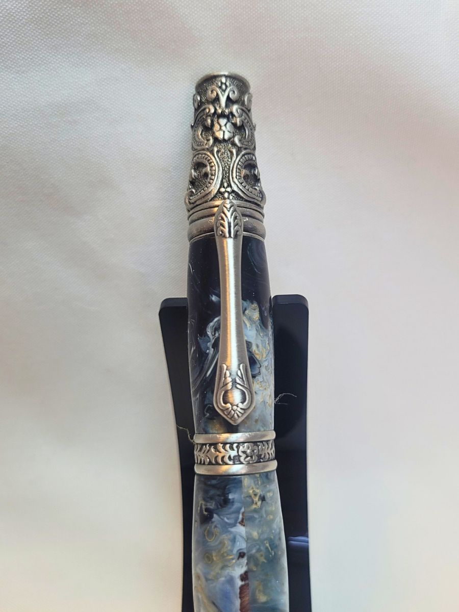 Stylo artisanal en résine époxy bleu et blanc avec copeaux de bois et finition étain victorien