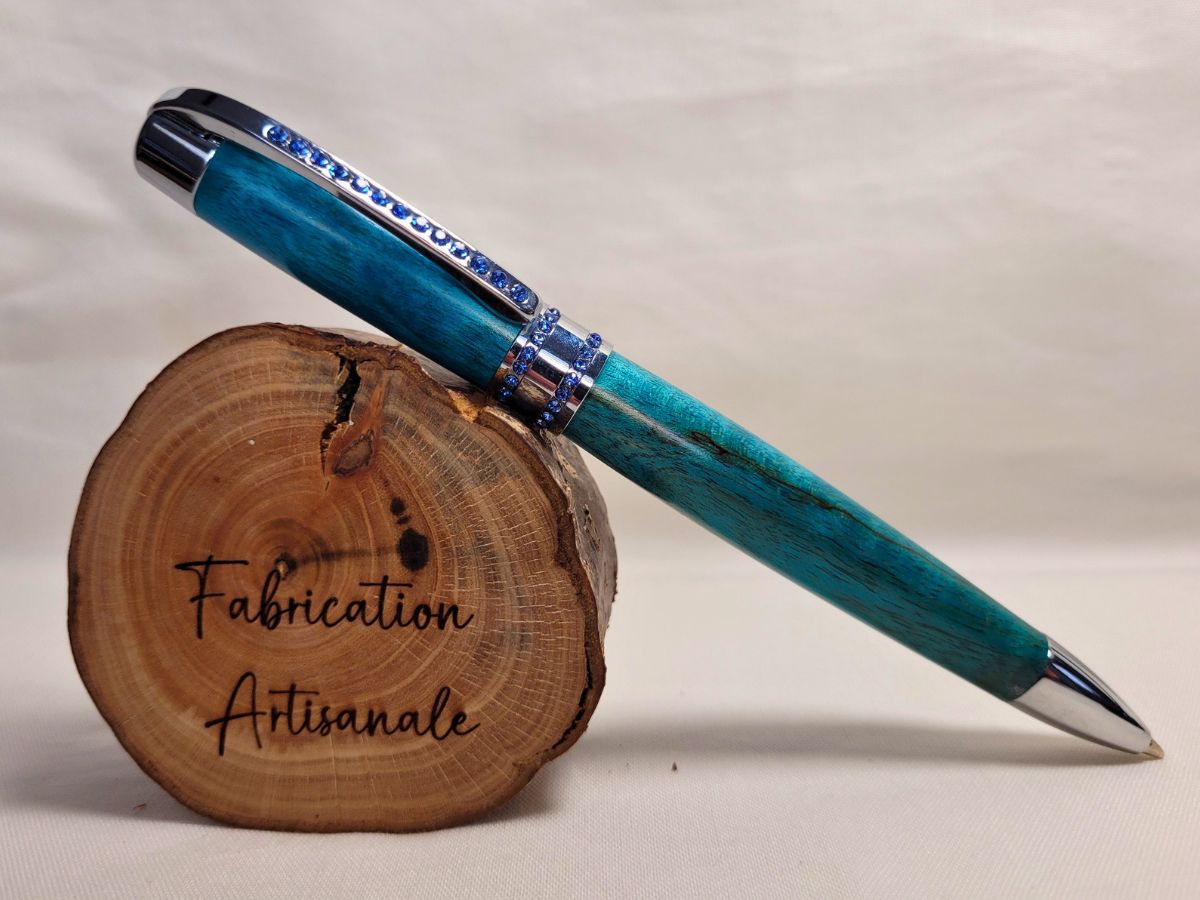 stylo en hêtre échauffé teinté bleu, finition chromée et strass bleus, création artisanale élégante.