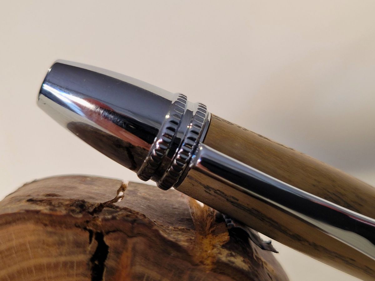 Détail du capuchon chromé du stylo Alliance en bois de frêne – finition brillante et travail artisanal soigné.