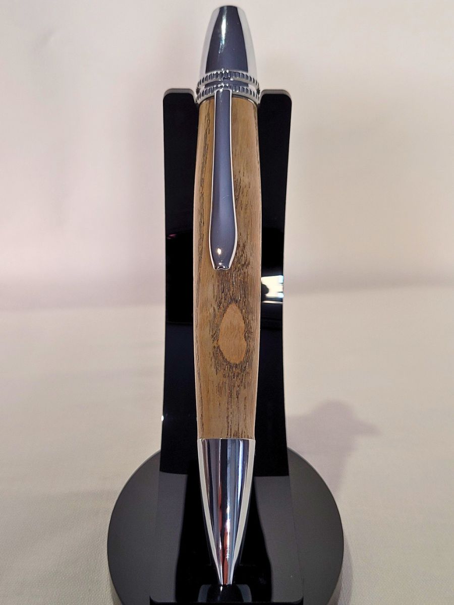 Stylo Alliance en bois de frêne avec placage chrome, présenté verticalement sur support noir – création artisanale française.
