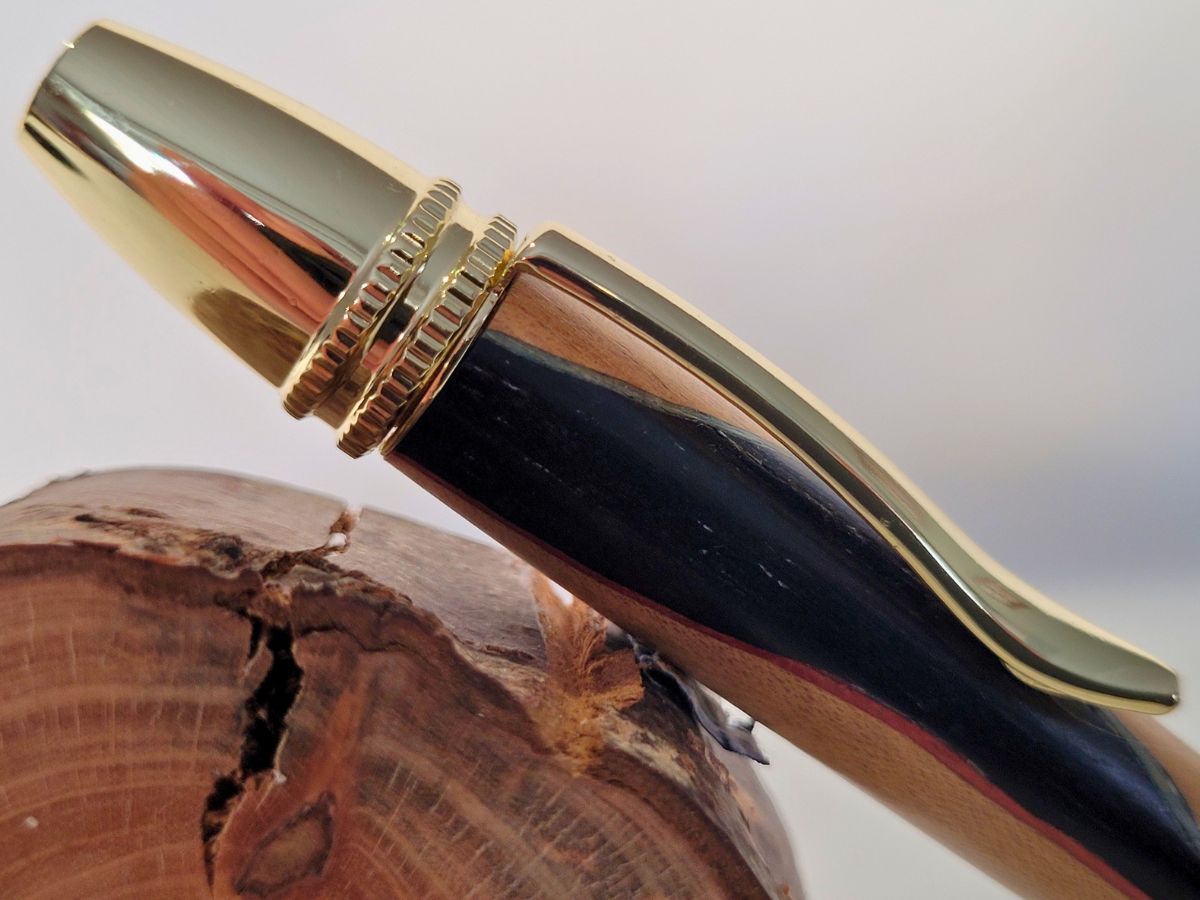 Détail du capuchon doré du stylo Alliance en charme et ébène – contraste lumineux entre bois clair et foncé, finition haut de gamme.