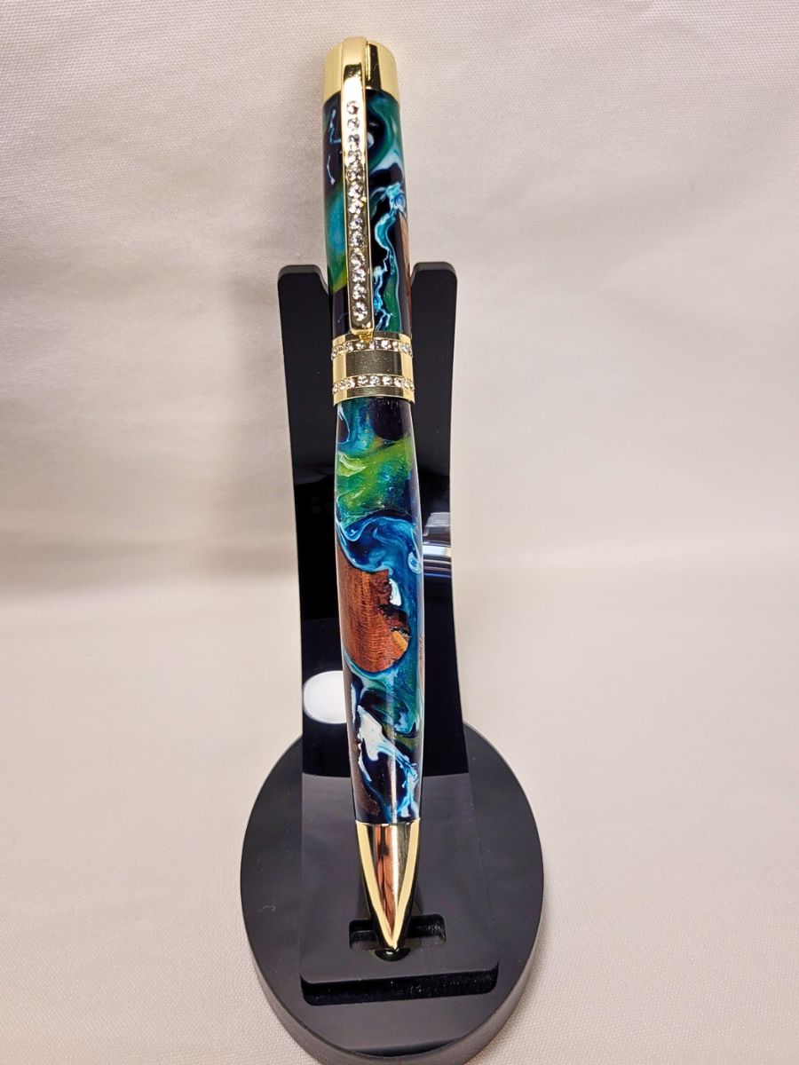 Stylo Princesse en hêtre et résine époxy bleu-blanc, finition or et strass, présenté sur support noir.