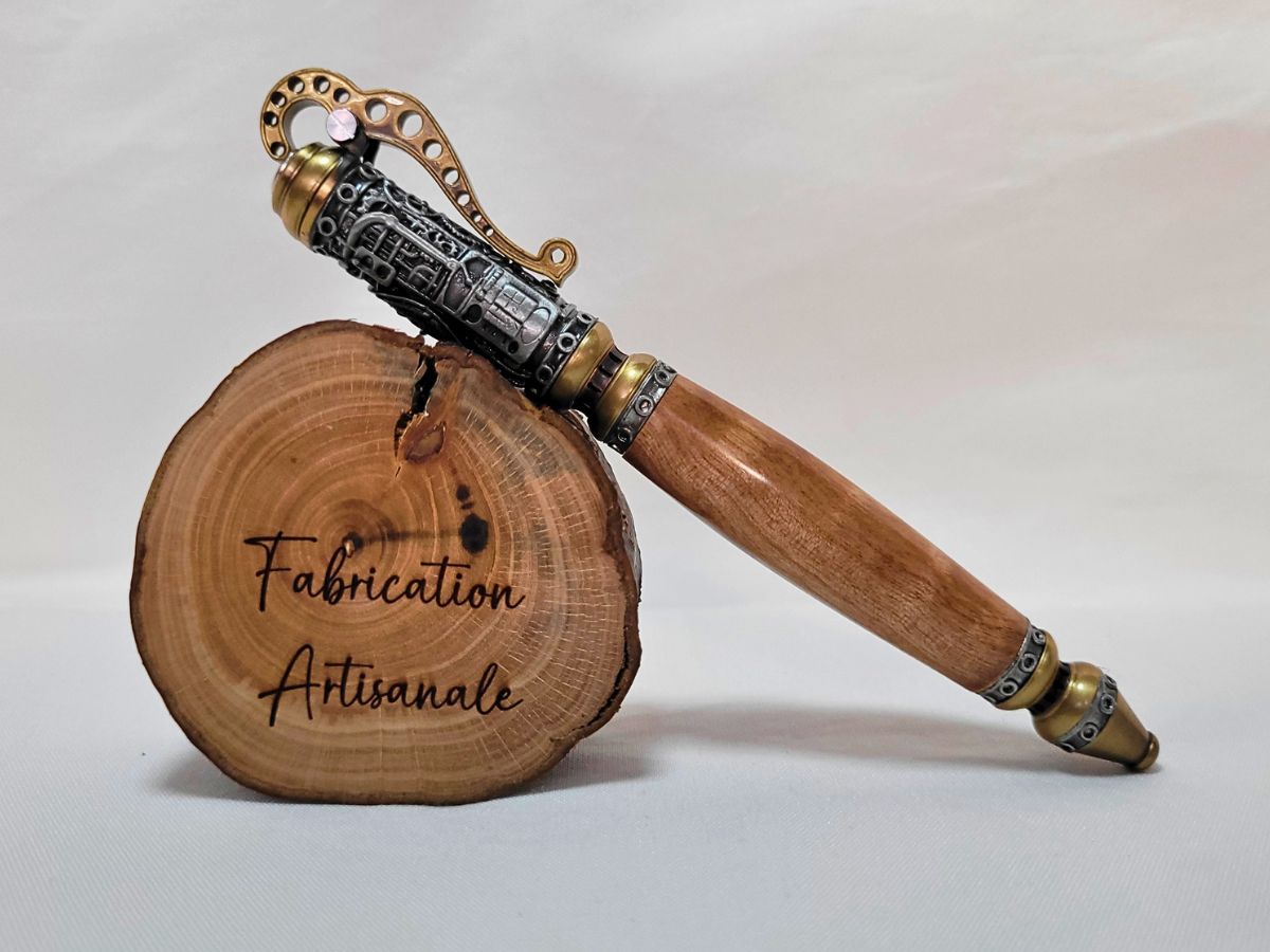 "Stylo steampunk artisanal en bois de bouleau posé sur rondin gravé Fabrication Artisanale, finitions étain-laiton"