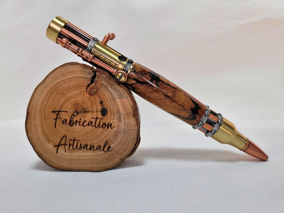 "Stylo steampunk artisanal en hêtre échauffé, finitions laiton et cuivre, posé sur rondin gravé Fabrication Artisanale"