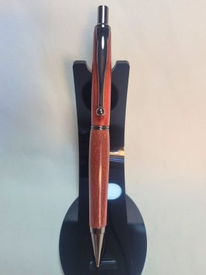 Porte‑mine artisanal en bois de Cœur rouge, finition noire brillante, sur support noir.