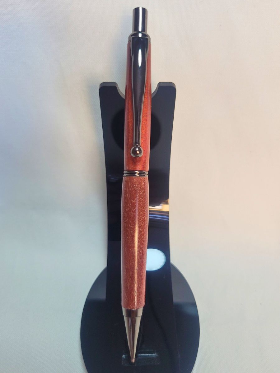 Porte‑mine artisanal en bois de Cœur rouge, finition noire brillante, sur support noir.