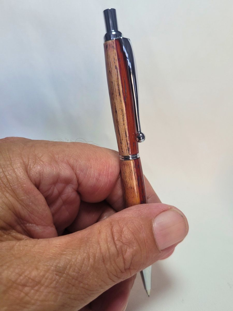 Porte‑mine artisanal en bois de padouk, frêne et bouleau, finition chromée, mécanisme clic, tenu en main.