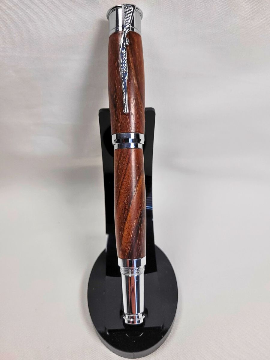 Stylo roller en bois de palissandre aux veinures naturelles, fabrication artisanale française avec détails chromés et prise en main confortable
