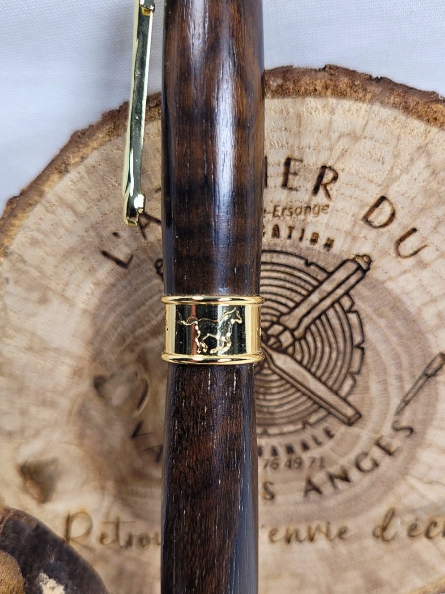 Détail de la bague centrale ciselée représentant des chevaux sur un roller artisanal en bois de wacapou doré