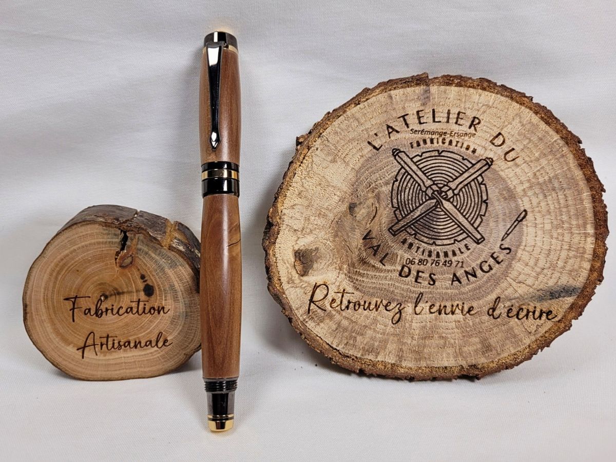 Roller de prestige en bois de prunier avec finitions noires brillantes et détails dorés présenté sur support artisanal