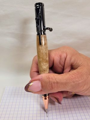 Stylo bille type parker G2 en bouleau ondé et placage noir et cuivre tenu en main