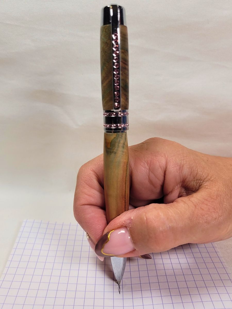 Stylo bille Princesse en bois de genévrier tourné à la main avec placage chromé et strass roses, démonstration d'écriture artisanale française