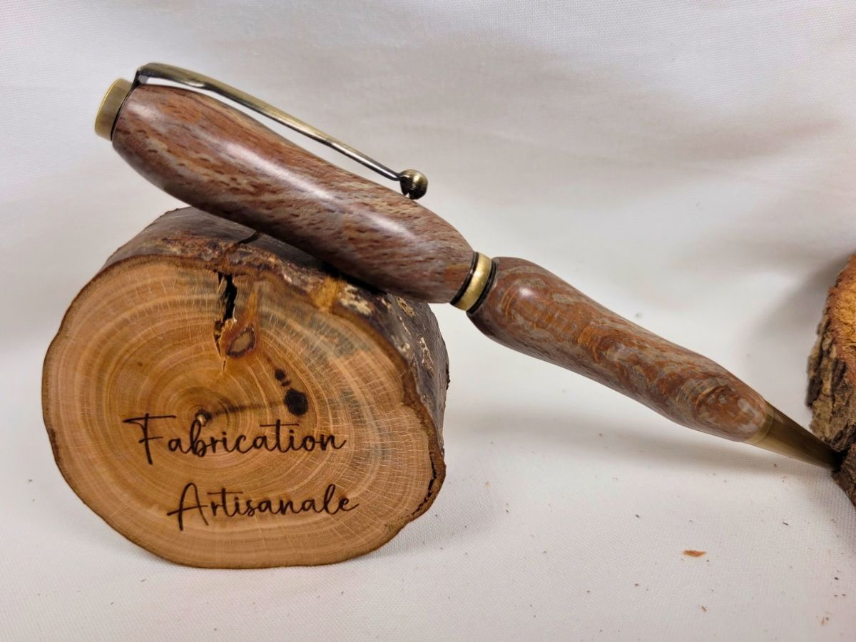 Stylo artisanal en bois de racine de hêtre mouchetée, placage bronze antique, posé sur rondin gravé Fabrication artisanale