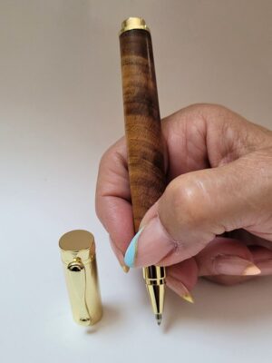 stylo roller magnétique artisanal en bois de cerisier tourné avec fibres apparentes, équipé d'un capuchon et d'une pointe en placage doré, présenté ouvert afin de mettre en valeur les motifs naturels du bois et le savoir-faire artisanal français.