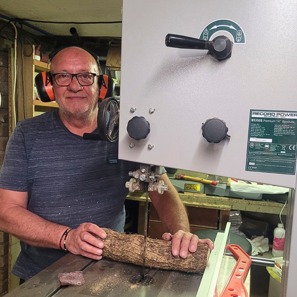 Découpe d'une branche de bois à la scie à ruban dans l'atelier du Val des Anges, préparation des futurs carrelets destinés à la fabrication de stylos artisanaux en bois, travail manuel réalisé dans l'atelier de la vallée de la Fensch