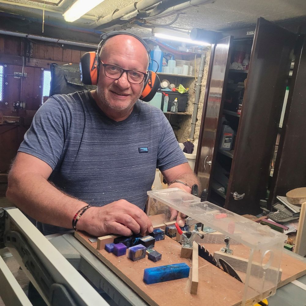 Fabrication artisanale de stylos en bois et résine dans l'atelier du Val des Anges, sélection et préparation de carrelets en résine colorée avant découpe et usinage, étape essentielle de la création d'un stylo unique tourné à la main