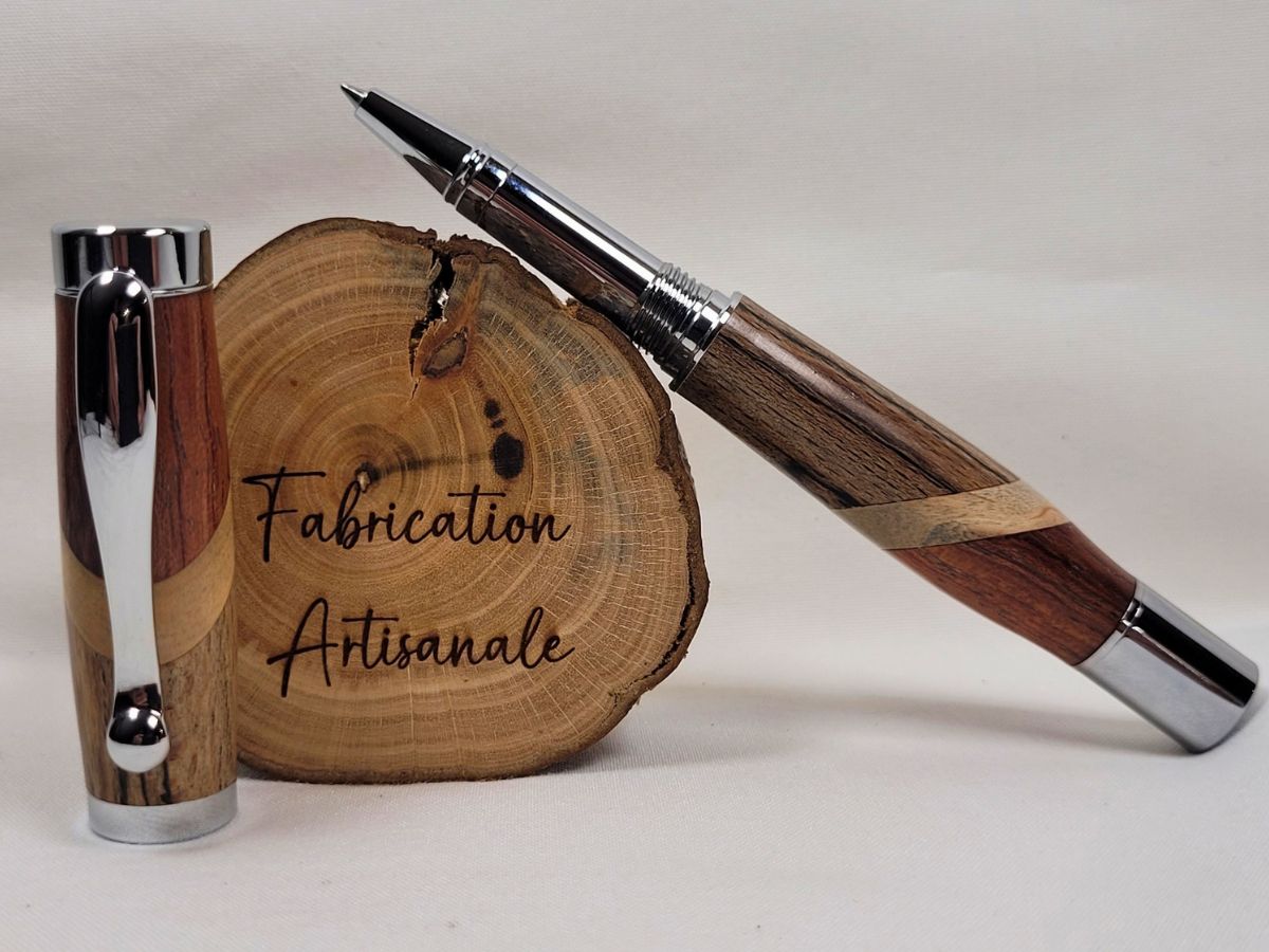 Roller artisanal ouvert en assemblage de hêtre échauffé, bouleau et padouk, équipé d'une recharge roller à pointe céramique fine, finition chromée brillante et veinages naturels visibles sur chaque partie du corps du stylo.