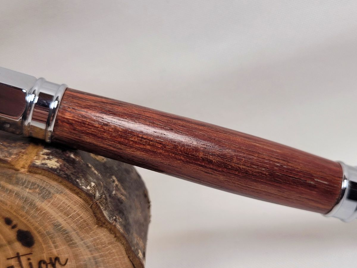 Détail du veinage naturel du bois d'amarante sur un stylo roller haut de gamme fabriqué artisanalement
