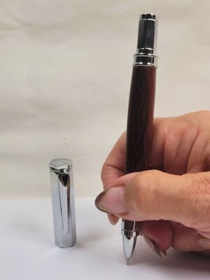 Stylo roller en amarante de Guyane tenu en main avec capuchon magnétique hexagonal chromé