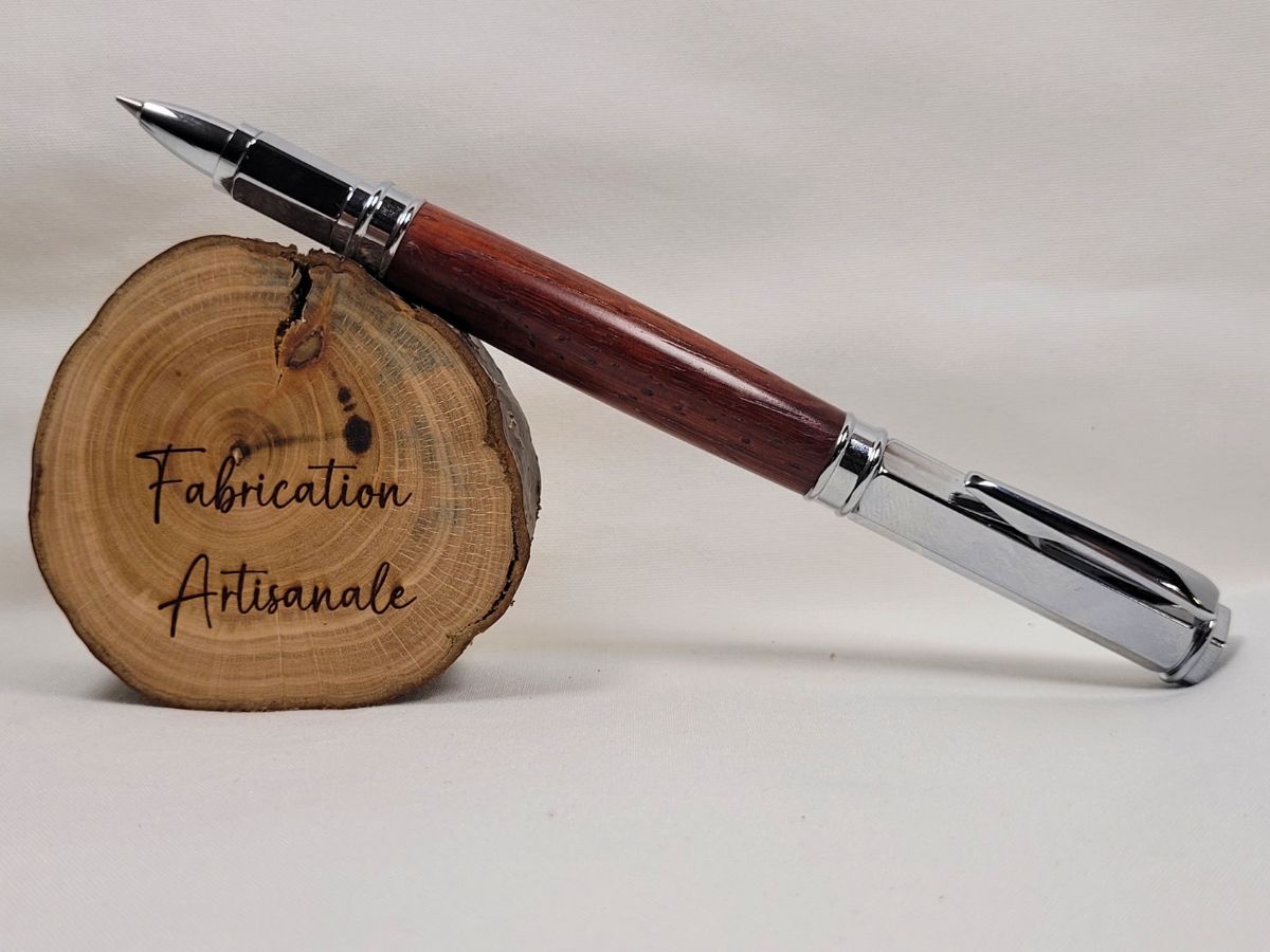 Stylo roller hexagonal magnétique en padouk présenté ouvert avec capuchon fixé à l'arrière, mettant en valeur les veinures naturelles du bois et la finition chromée brillante.
