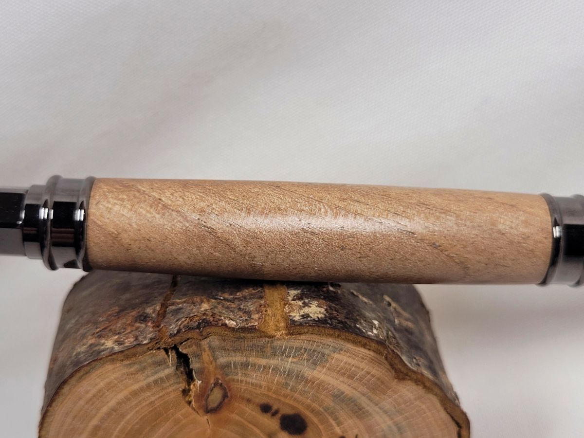 Détail du veinage naturel du noyer sur un stylo roller artisanal à placage noir