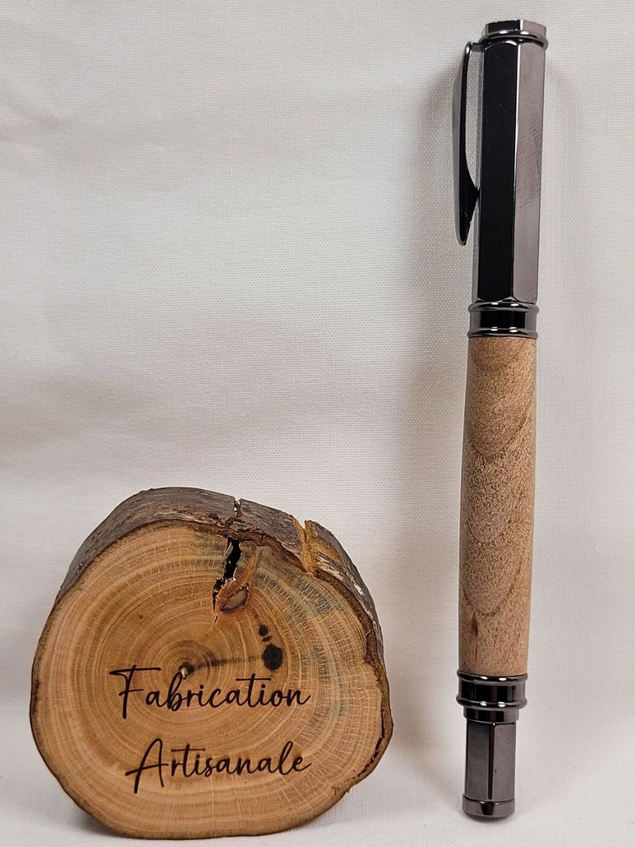 Stylo roller artisanal en noyer avec capuchon magnétique hexagonal noir debout sur rondelle de bois