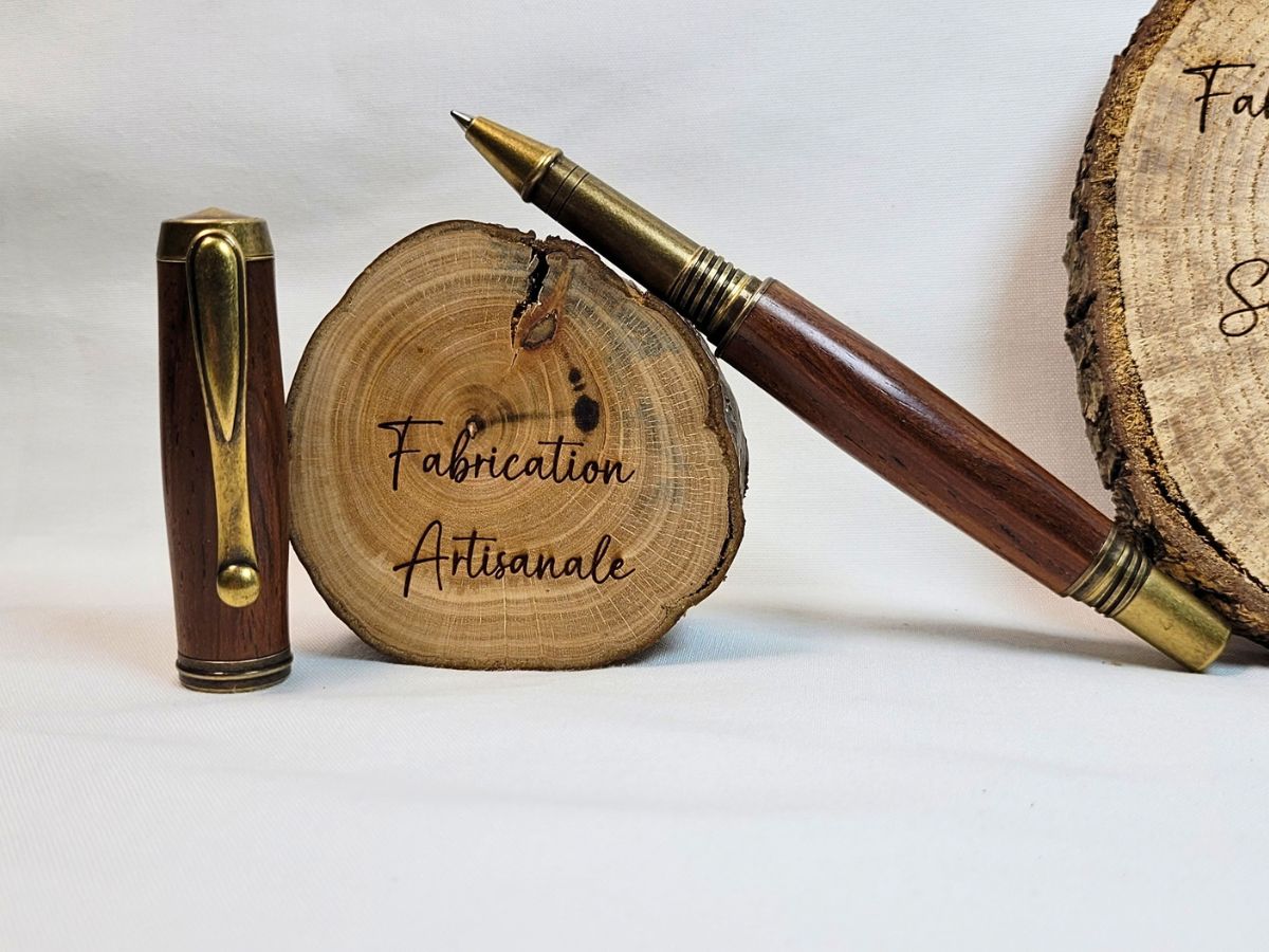 Détail du clip bronze antique sur roller artisanal en bois de padouk
