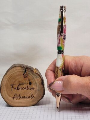 Stylo Slim Premium artisanal tenu en main, placage or rose, corps hybride en bois de hêtre et résine époxy multicolore à pois colorés, démonstration du format Slim et de la prise en main confortable