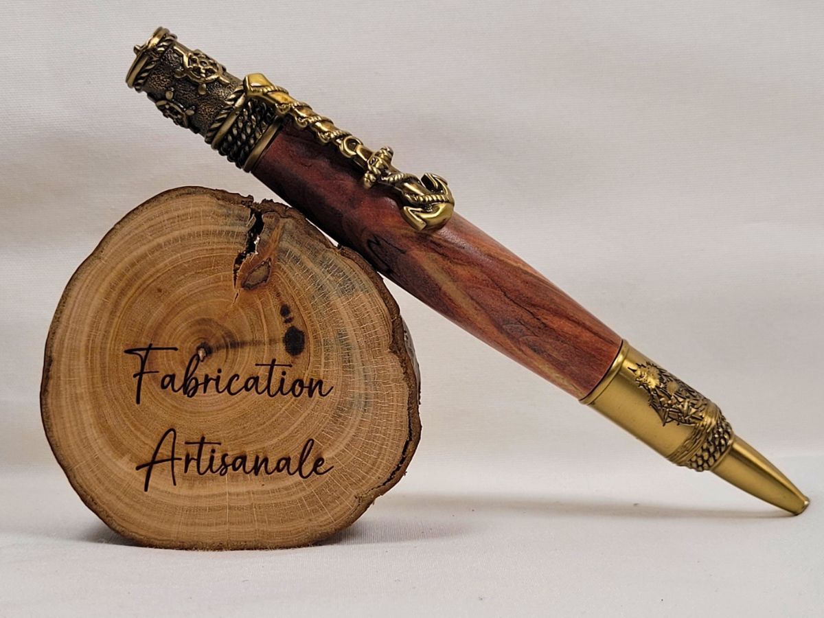 Stylo artisanal en bois de cerisier avec finitions en laiton ciselé, ancre marine décorative, boussole au sommet et voilier gravé, fabrication artisanale française