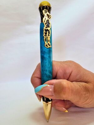 Stylo bille basket-ball artisanal tenu en main, bois de bouleau teinté bleu aux nuances lumineuses, placage or et noir ciselé, joueur effectuant un lancer de ballon sur l'épingle et mécanisme twist rechargeable Parker G2